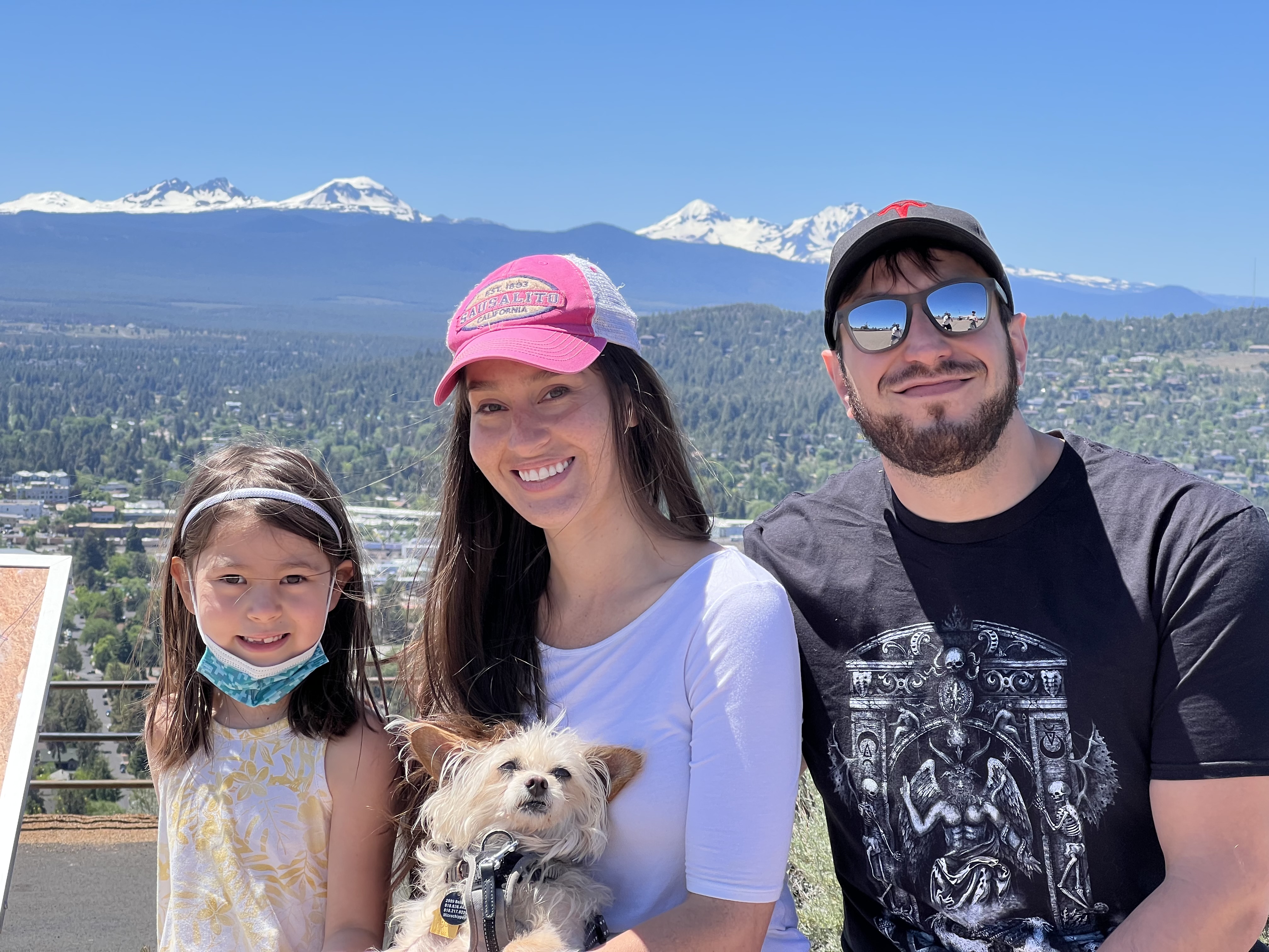 Samantha with friends and a small dog in front of a mountain view