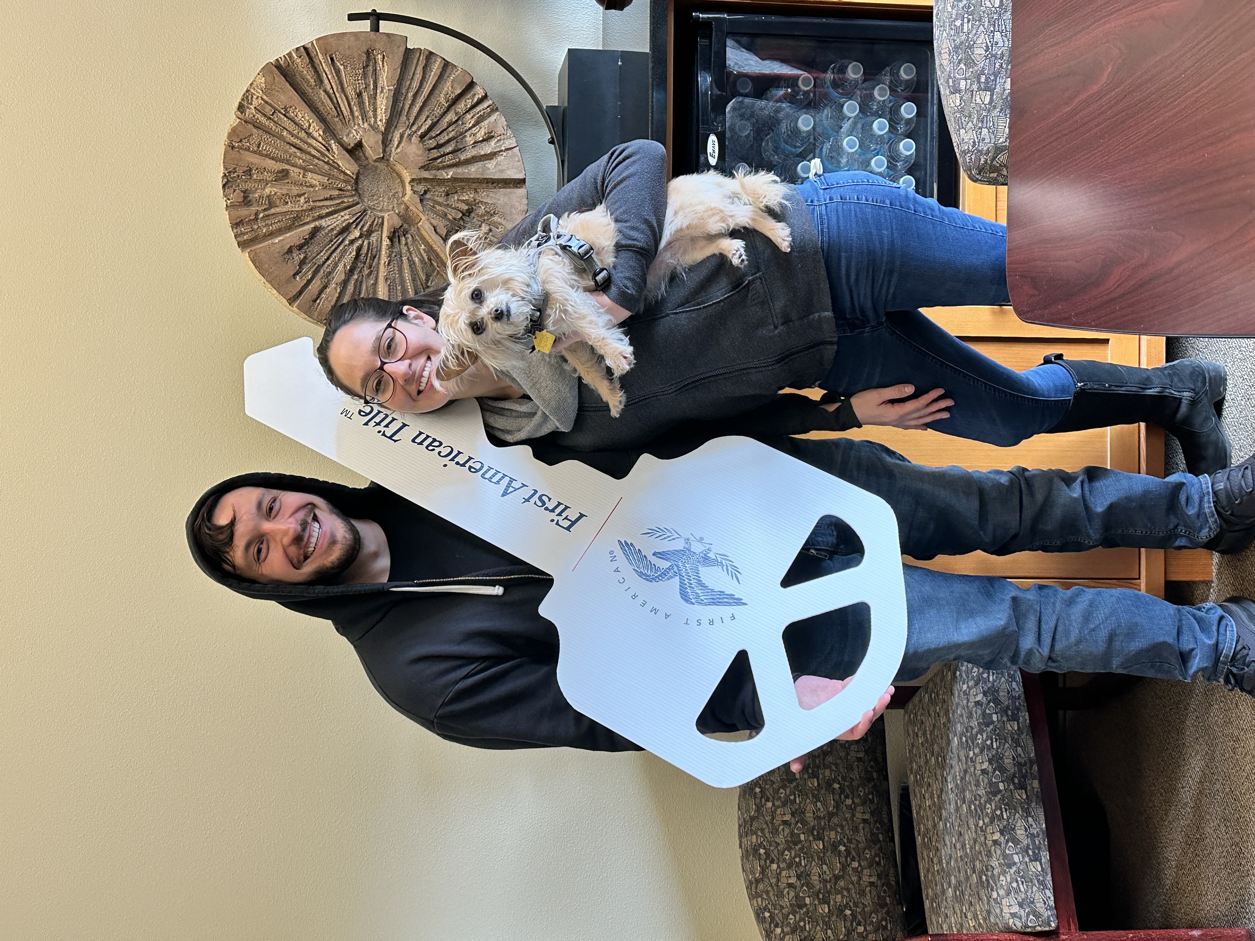 Samantha and a friend holding a giant First American Title key