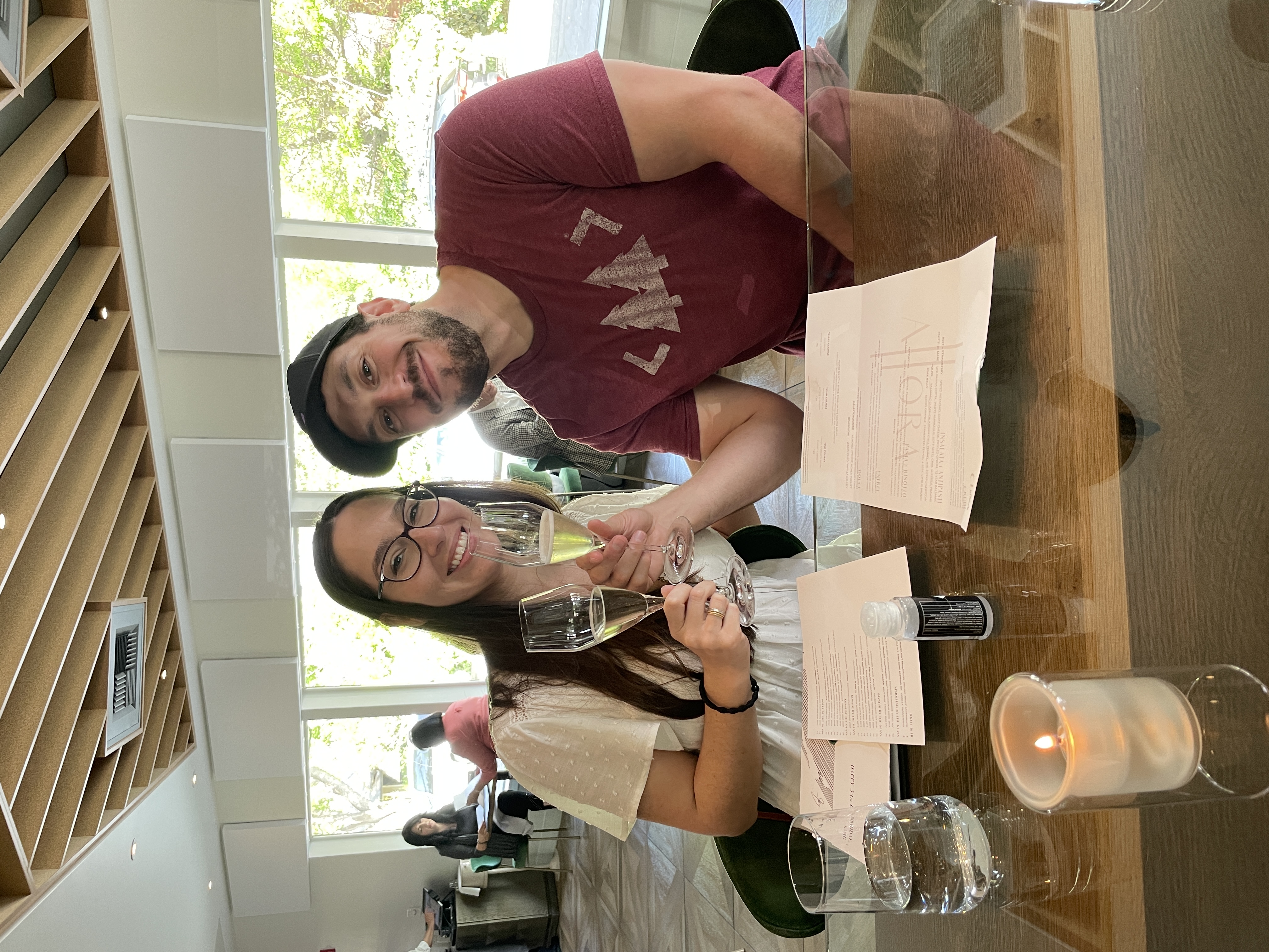 Samantha and a friend toasting with glasses at a table